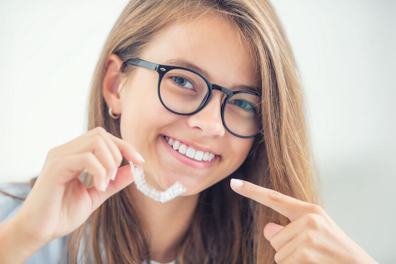 teen holding aligner